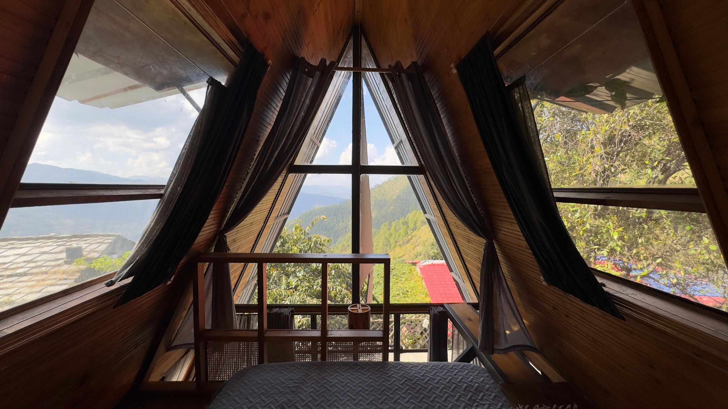 The view from the bed in the A-frame loft, through the glass gable to the hills