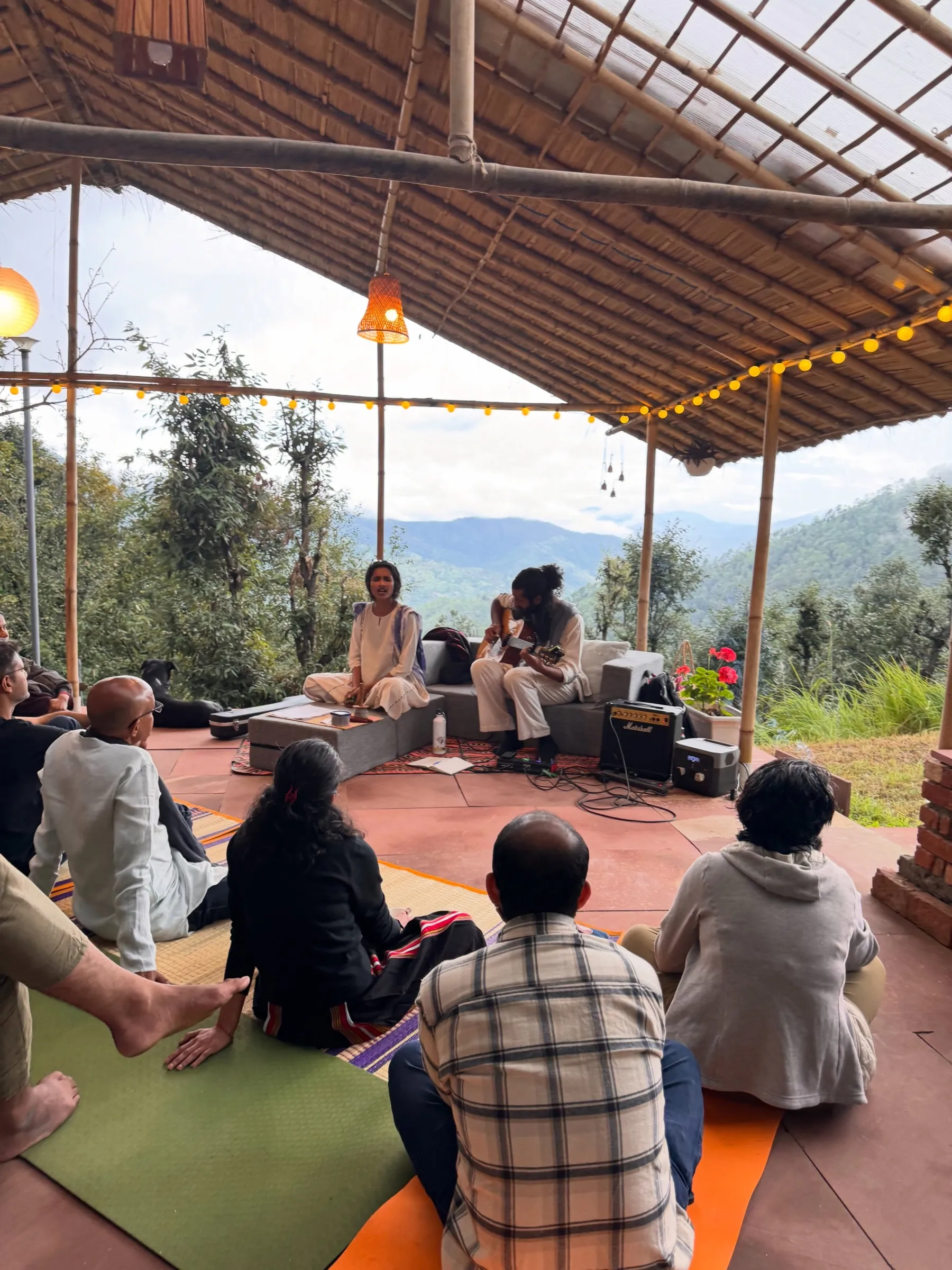 People sitting together on rugs at Turiya, in the afternoon