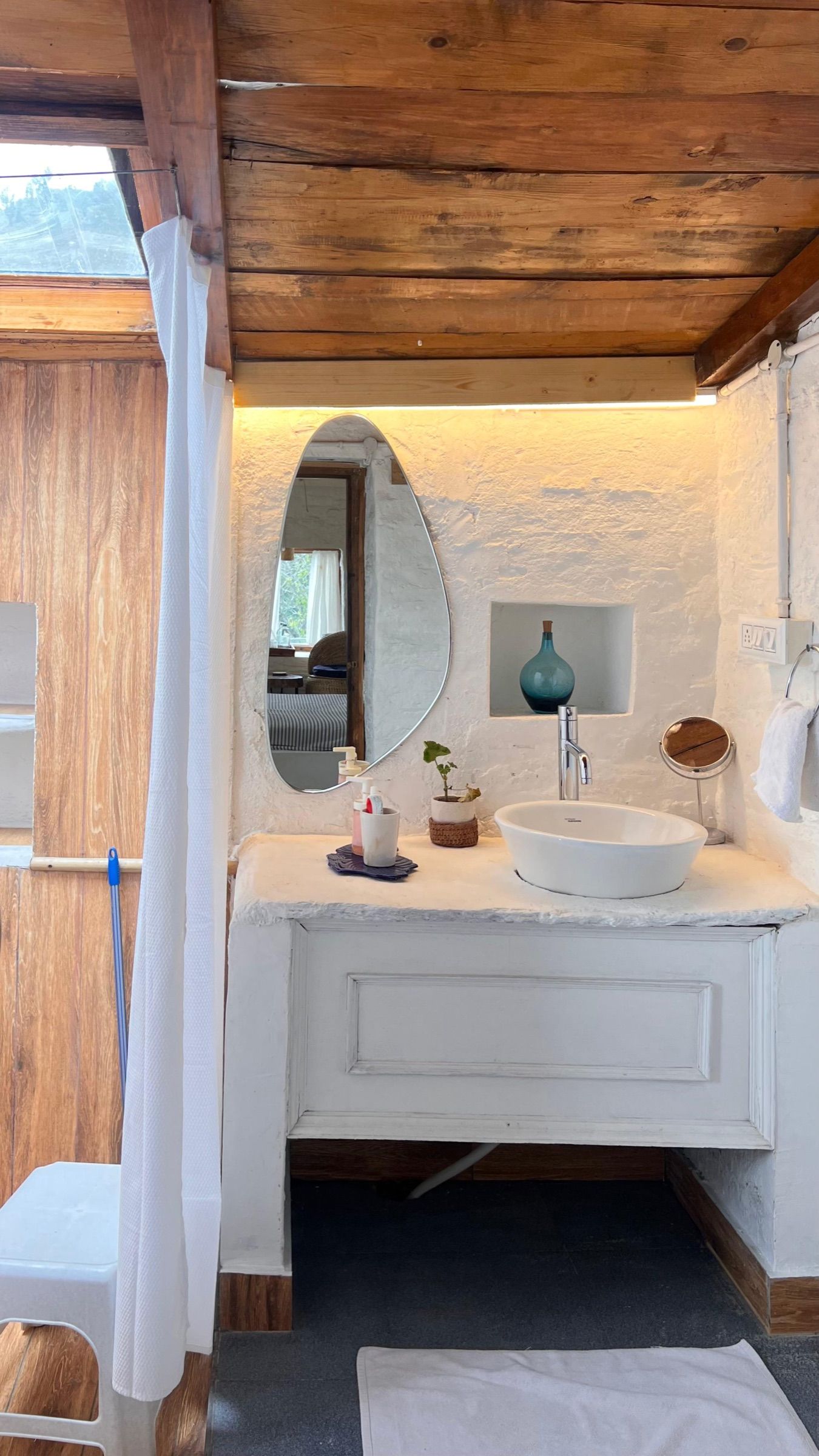 The basin in Kintsugi's bathroom, under a wooden ceiling and a skylight