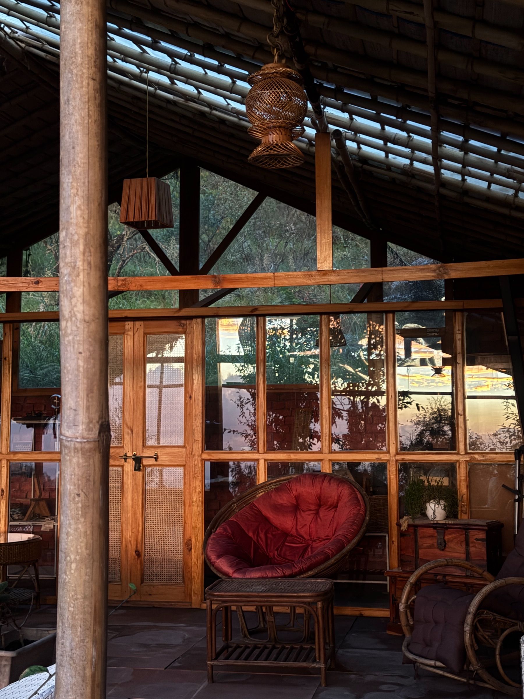 Turiya, an open pavilion with a bamboo and glass roof, cane chairs and a glass-walled room at the back