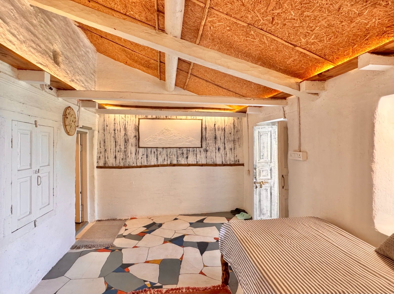 The study, with a mountain picture above a striped day bed